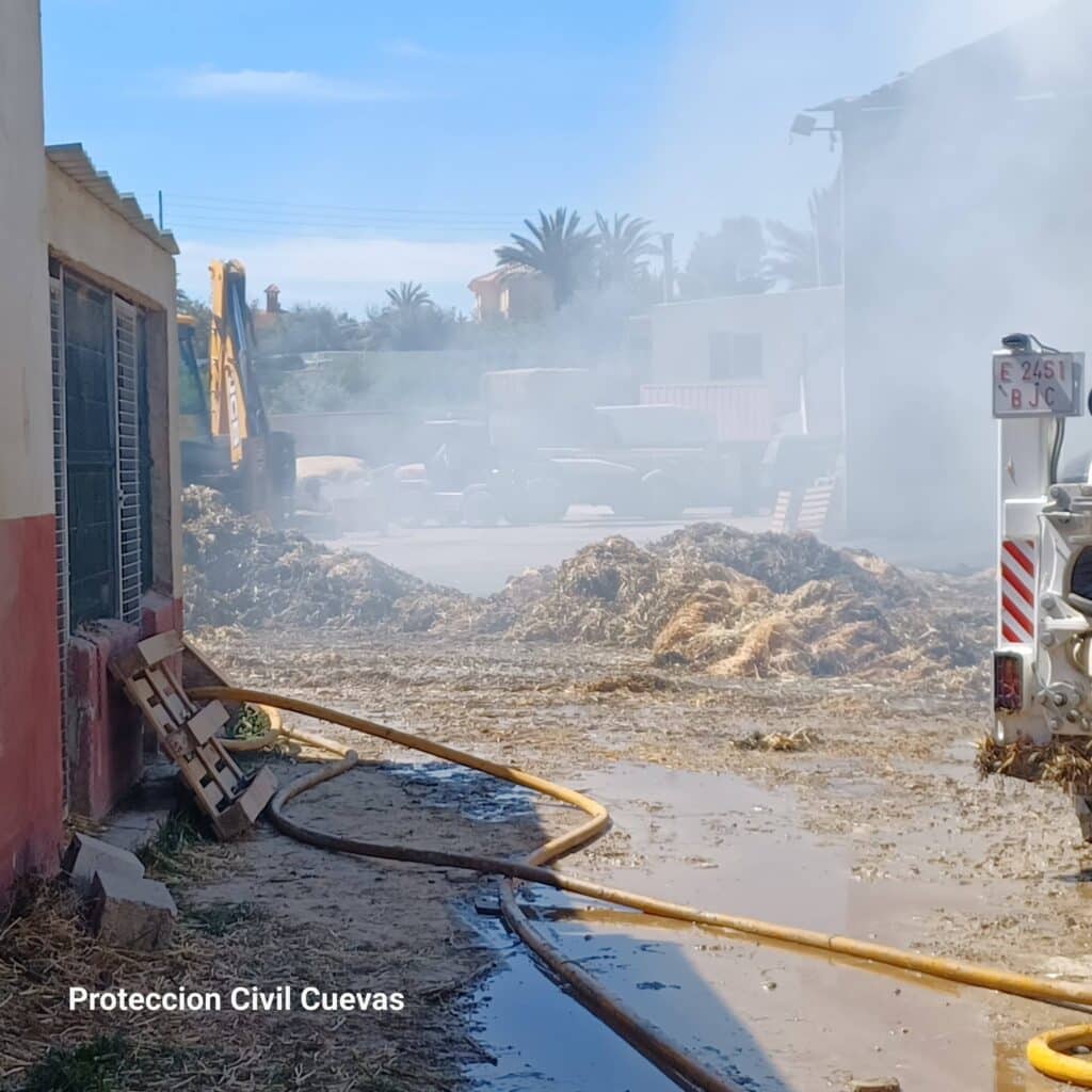 Vecinos y bomberos trabajan codo a codo en Cuevas para sofocar un incendio en una nave agrícola